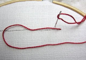 Coral Stitch #1.  Take the needle to the back above the line with the thread in a loop.  @StitchIdyllic